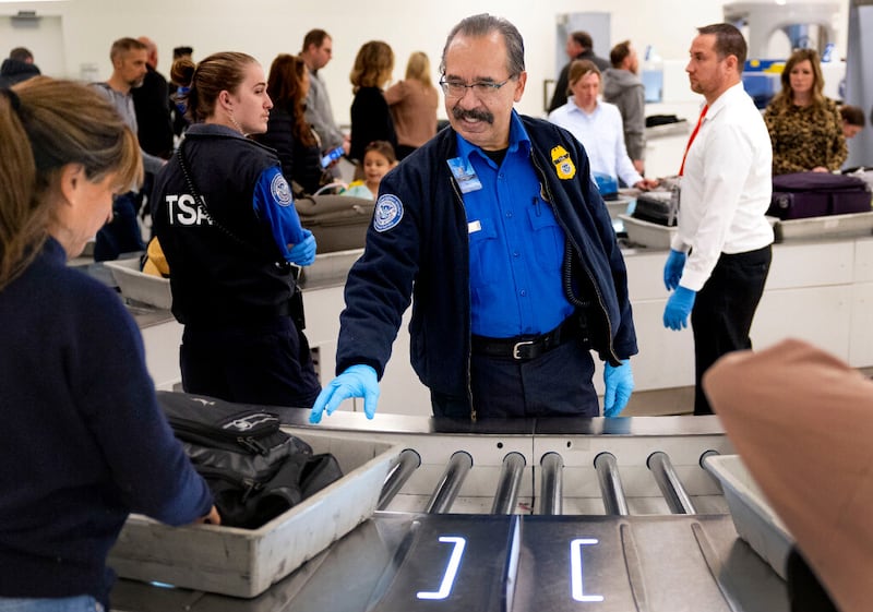 TSA officer Jaime Bueno helps travelers go through security at Salt Lake City International Airport. | Photo by Laura Seitz, Deseret News