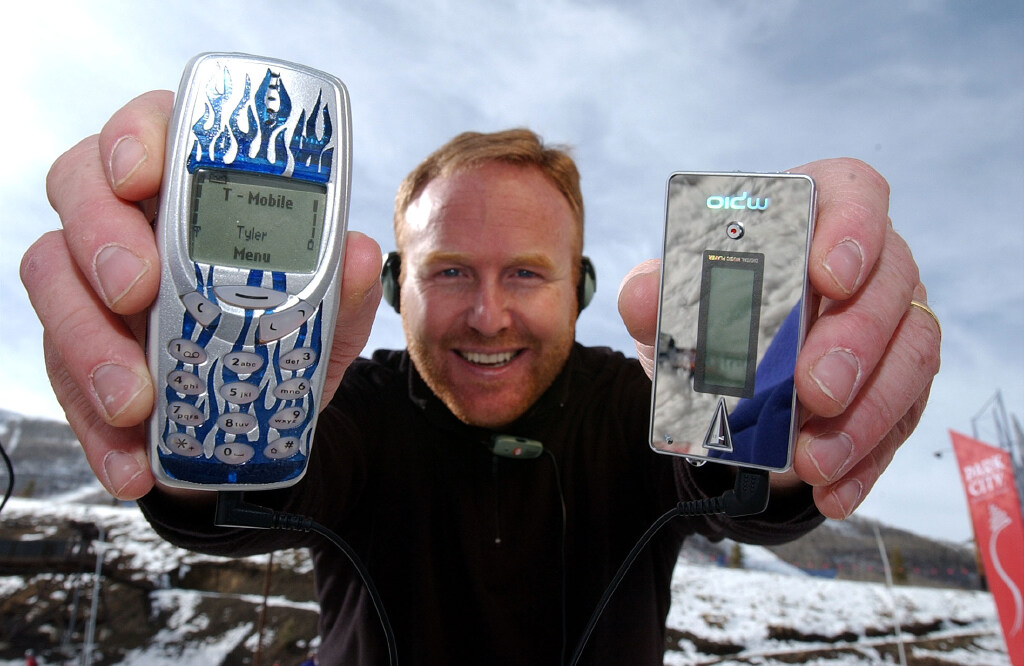 Rick Alden displays his cell phone and MP3 player, both connected by a Skullcandy LINK wire, in 2003. | Photo by Laura Seitz, Deseret News